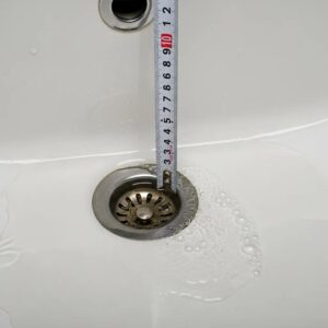 Close-up of clogged sink with water pooling, indicating blocked drain issue
