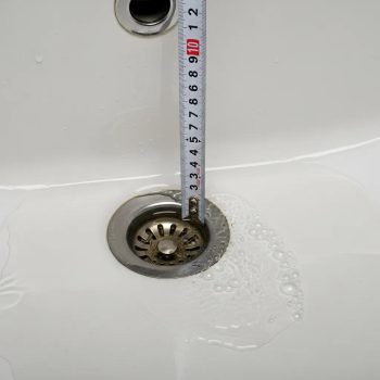 Close-up of clogged sink with water pooling, indicating blocked drain issue